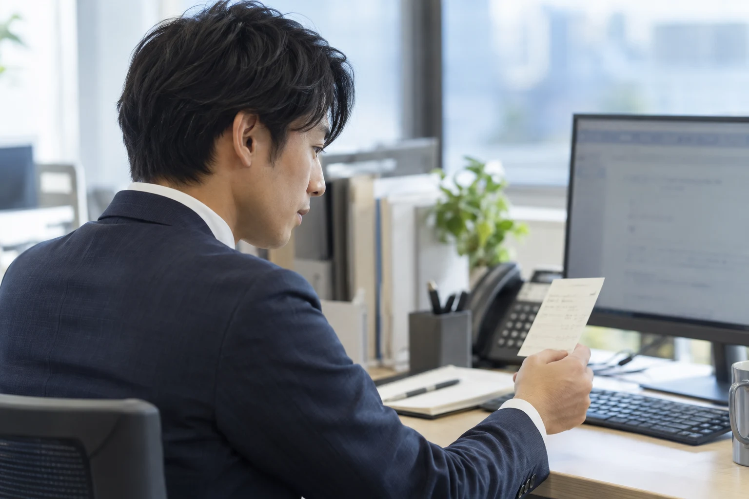 顧客対応後、メモと画面を確認して記録する業務シーン